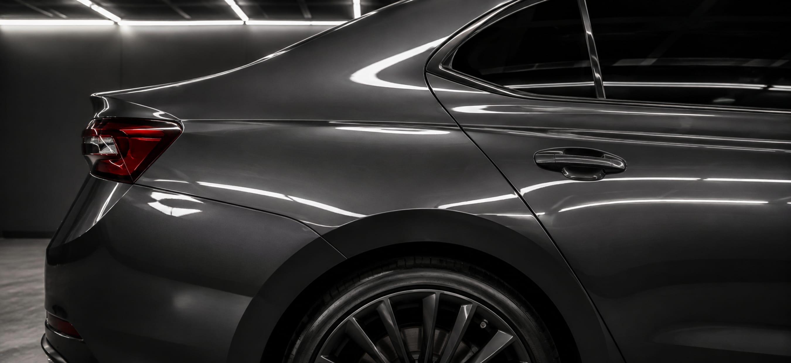The same car panel after two-stage correction: the reflection is unbroken and the colour reads deep.